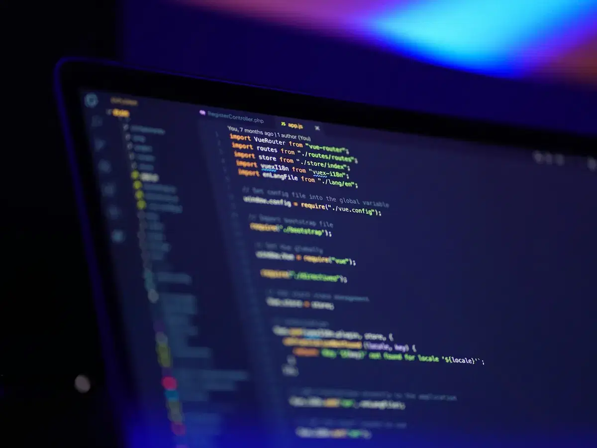 Source code displayed on a laptop screen in low light