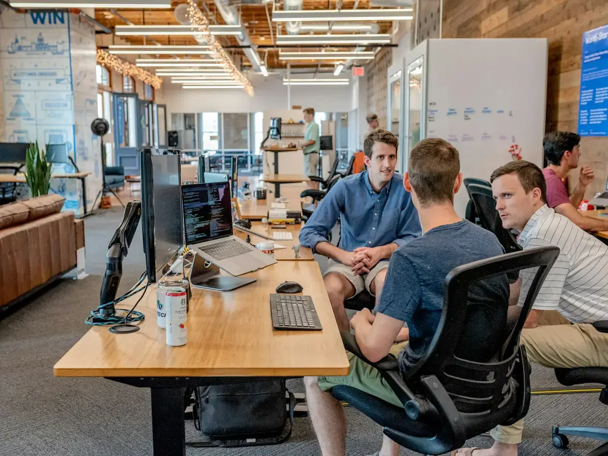 Team discussing work around desks in a modern office